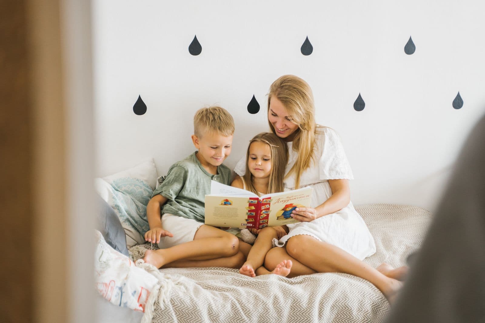 Caregiver reading a storybook with two young children